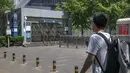 <p>Seorang pria yang mengenakan masker melihat ke pintu keluar stasiun kereta bawah tanah yang tertutup di Beijing, China Rabu (4/5/2022). Beijing pada hari Rabu ini menutup lebih dari 40 stasiun kereta bawah tanah, sekitar sepersepuluh dari jaringan kereta, sebagai bagian dari tindakan untuk menghentikan penyebaran Covid-19. (AP Photo/Mark Schiefelbein)</p>