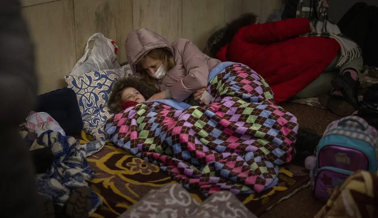 Orang-orang beristirahat di kereta bawah tanah Kiev, menggunakannya sebagai tempat perlindungan bom di ibu kota Ukraina, Kamis, 24 Februari 2022. Warga di Kiev tampak berlindung di stasiun bawah tanah kota dan tempat-tempat aman lainnya untuk menghindari invasi Rusia. (AP Photo/Emilio Morenatti)