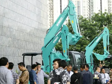 Pengunjung mengamati aneka alat berat yang dipajang dari produk Kobelco di Jakarta, Jumat (15/2). Pameran ini bertujuan untuk memenuhi kebutuhan sektor kehutanan, pertanian, pertambangan dan konstruksi di Indonesia. (Liputan6.com/Faizal Fanani)