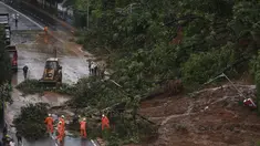 Petugas pemadam kebakaran membersihkan jalan setelah tanah longsor yang disebabkan oleh curah hujan di Mumbai, India, Rabu, (6/8/2020). Musim hujan India berlangsung dari Juni hingga September. (AP Photo / Rafiq Maqbool)