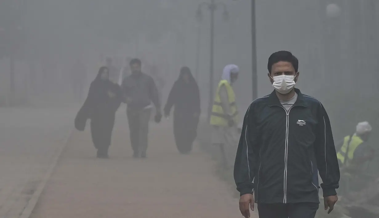 Orang-orang berjalan di sekitar taman di tengah kondisi kabut asap tebal di Lahore pada Kamis 7 November 2024. (Arif ALI/AFP)