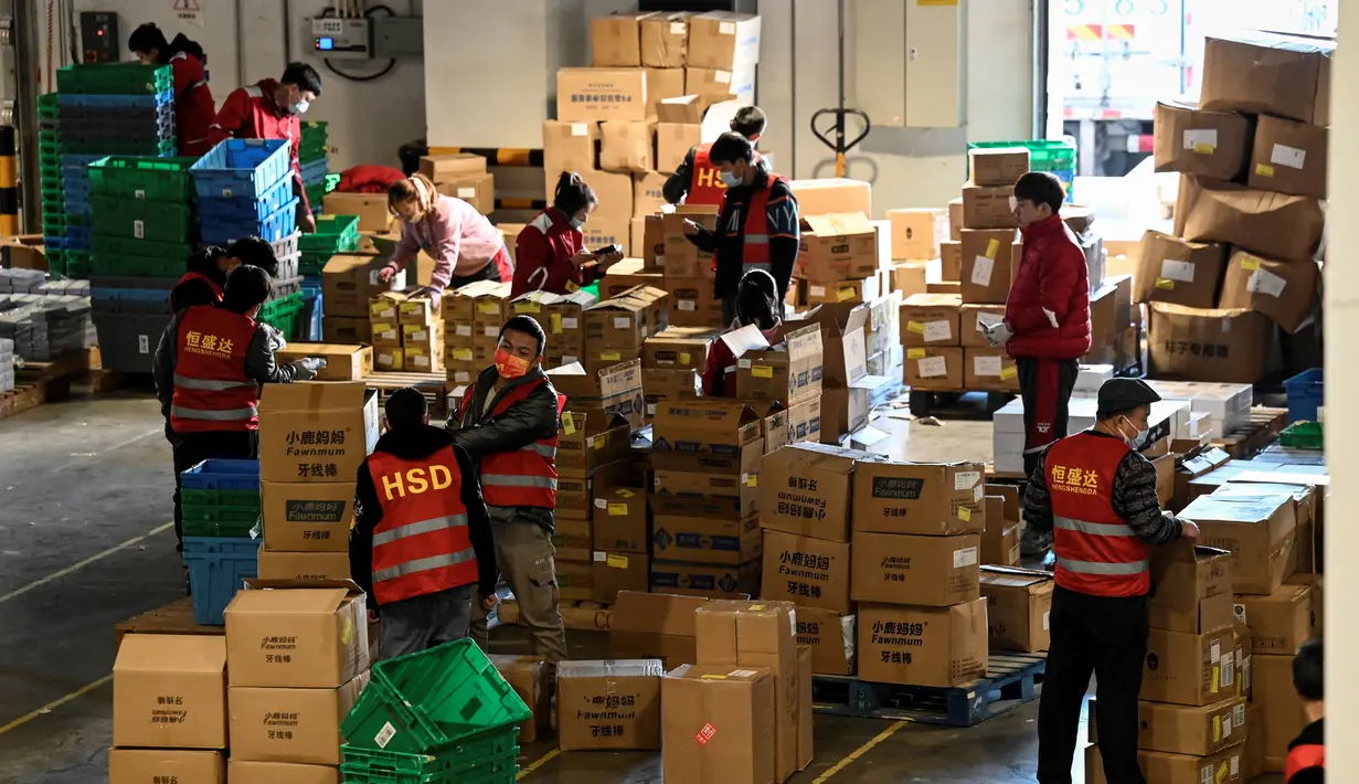 Pekerja menyortir paket untuk pengiriman menjelang festival belanja Singles' Day yang jatuh pada 11 November, di gudang JD.com di Beijing, Selasa (9/11/2021). Hari belanja online nasional (Harbolnas) atau single day di China menjadi festival belanja online terbesar di dunia. (Giok GAO / AFP)
