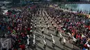 Warga memadati pinggiran jalan di kawasan Bundaran HI saat parade bendera digelar, Jakarta, Minggu (30/10). Parade ini merupakan rangkaian arak-arakan parade Bendera Menjelang Sidang Umum Interpol Ke-85. (Liputan6.com/Johan Tallo)