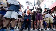 Seorang pendemo (tengah) membawa boneka berwajah Presiden AS, Donald Trump dalam demontrasi di Times Square, New York, Rabu (26/7). Demonstrasi digelar setelah Trump melarang kaum transgender menjadi personel militer AS. (AP/Frank Franklin II)