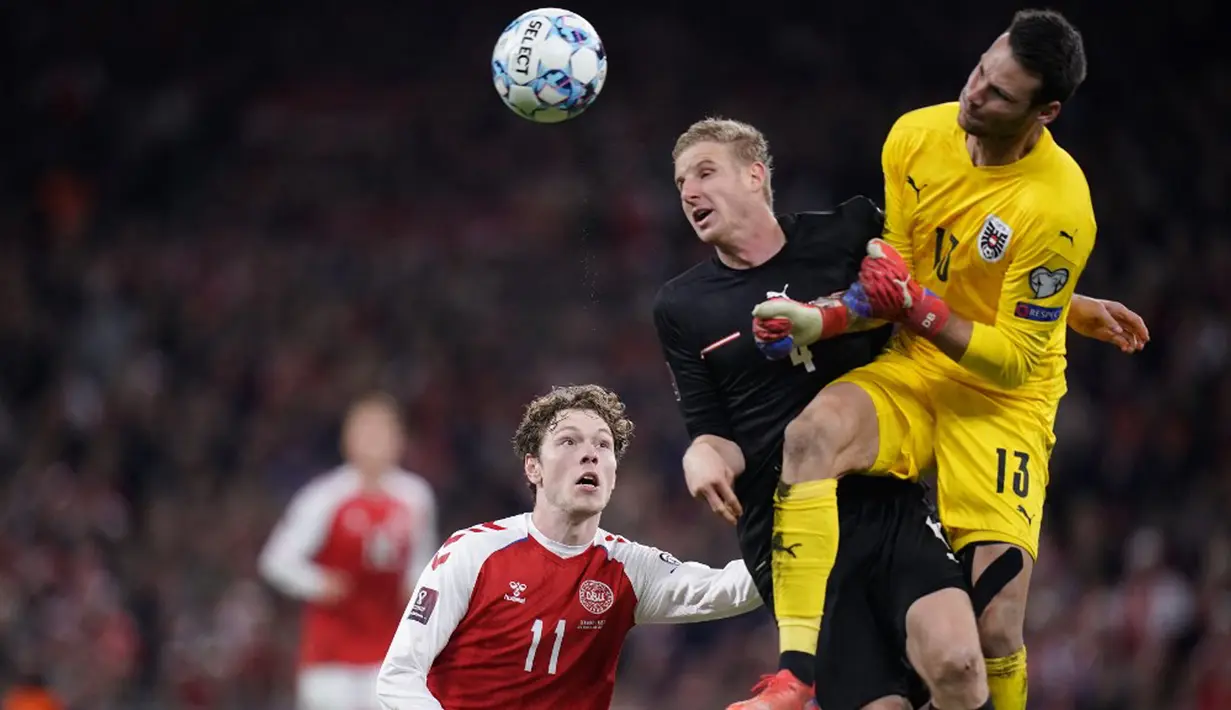 (Kiri-Kanan) Pemain Denmark Andreas Skov Olsen, pemain Austria Martin Hinteregger dan penjaga gawang Austria Daniel Bachmann bersaing memperebutkan bola pada pertandingan Grup F kualifikasi Piala Dunia 2022 di Kopenhagen, Denmark, Selasa (12/10/2021). (Liselotte Sabroe/Ritzau Scanpix/AFP)