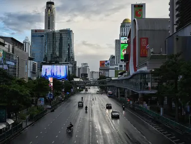 Kendaraan berjalan di persimpangan Ratchaprasong pada hari pertama penguncian COVID-19 yang lebih ketat di Bangkok, Senin (12/7/2021).  Thailand menerapkan lockdown untuk menekan laju penyebaran virus corona pada Senin, 12 Juli 2021 di Bangkok dan provinsi sekitarnya. (Lillian SUWANRUMPHA/AFP)