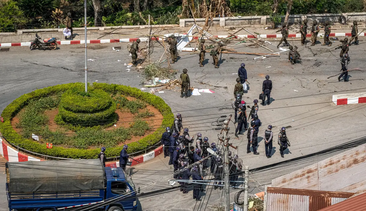 Tentara dan polisi membersihkan jalan yang diblokir oleh pengunjuk rasa di Taunggyi, sebuah kota di Negara Bagian Shan (28/2/2021).  Jika ditotal, jumlah pengunjuk rasa yang tewas sejak kudeta militer menjadi sedikitnya 21 orang. (AFP/STR)