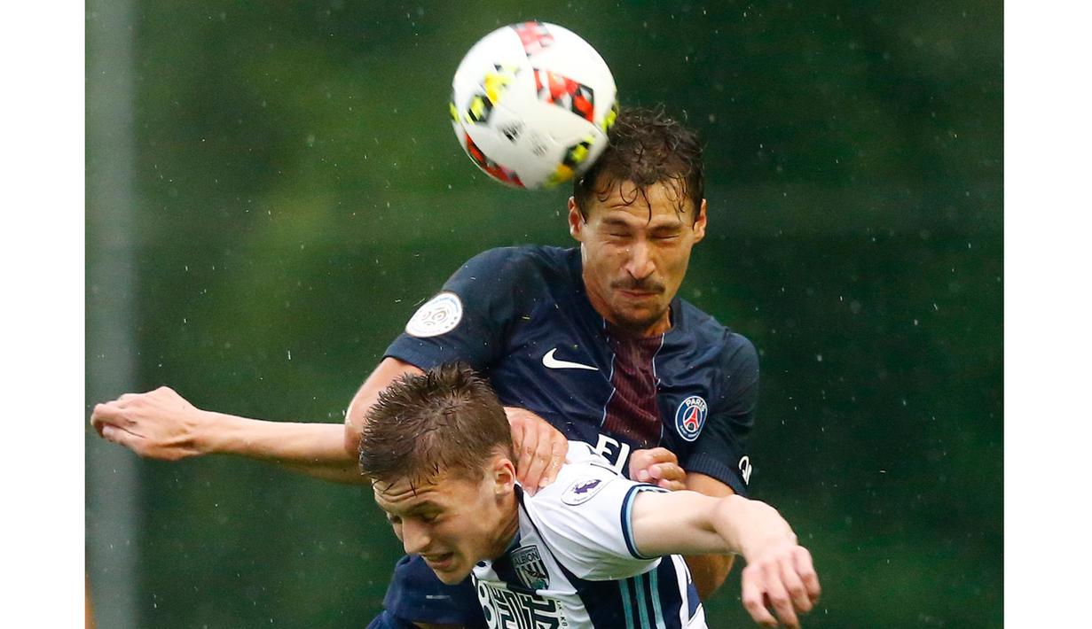 Pemain Paris St Germain, Benjamin Stambouli (atas) menghadang sundulan pemain West Brom pada laga uji coba di Schladming Athletic Area, Austria, (13/7/2016). PSG menang 2-1. (Action Images via Reuters/Dominic Ebenbichler)