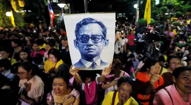 Rakyat Thailand membawa gambar Raja Thailand Bhumibol Adulyadej di luar RS Siriraj, Bangkok, Thailand, Kamis (13/10). (REUTERS / Jorge Silva)