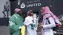 Tiga pria dari Arab Saudi berbicara di luar lapangan sebelum pertandingan sepak bola Liga Premier Inggris antara Newcastle dan Tottenham Hotspur di St. James' Park di Newcastle, Inggris, Minggu 17 Oktober 2021. (AP/Jon Super)