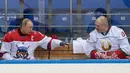 Presiden Rusia Vladimir Putin (kiri) dan Presiden Belarus Alexander Lukashenko (kanan) berbincang disela-sela pertandingan hoki es di Shayba Arena, Resor Laut Hitam Sochi, Rusia, (15/2). (Sergei Chirikov / Pool / AFP)