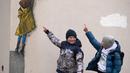 Anak-anak menunjuk ke sebuah karya seni dari seniman jalanan terkenal TvBoy di pusat Kota Bucha, Ukraina, 30 Januari 2023. Karya seni yang dibuat untuk menghormati para korban perang Rusia-Ukraina tersebut mengandung pesan kelahiran kembali dan harapan serta berharap agar konflik segera berakhir. (AP Photo/Efrem Lukatsky)
