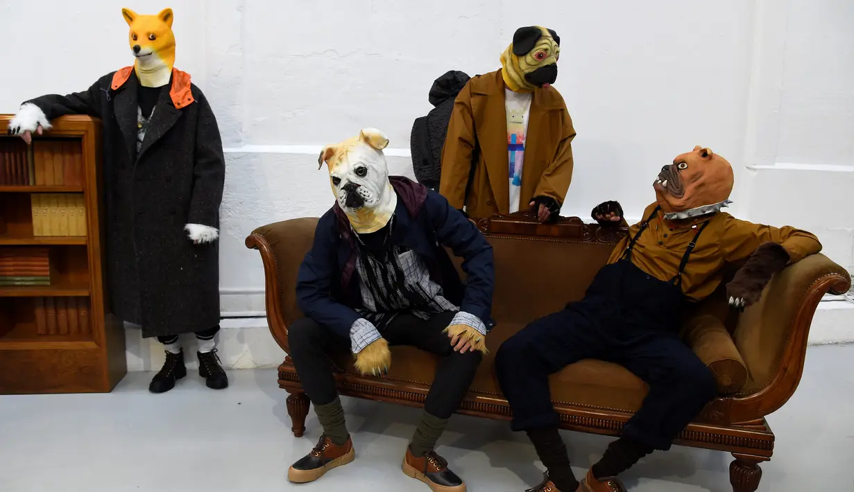 Sejumlah model mengenakan topeng anjing berpose saat membawakan kreasi Julien David untuk koleksi Fall / Winter 2018/2019 dalam Paris Men Fashion Week di Paris (17/1). (AFP Photo/Bertrand Guay)