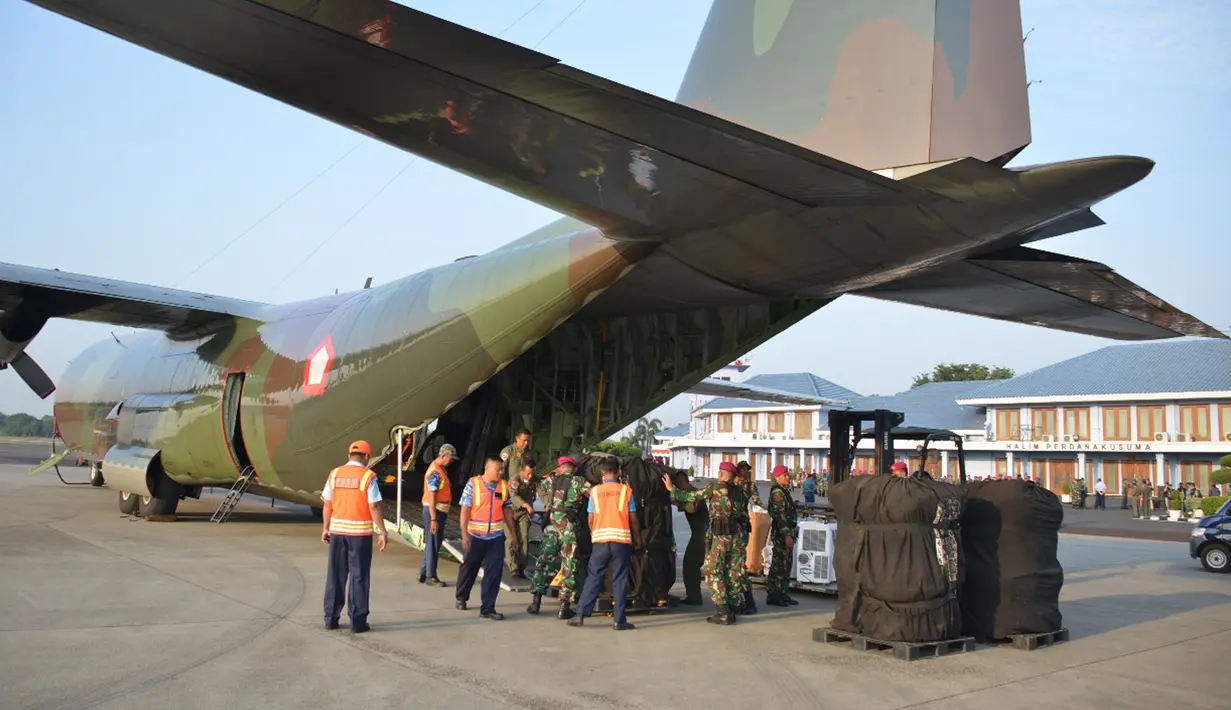 Satgas Pasukan Reaksi Cepat Penanggulangan Bencana (PRCPB) Marinir memasukkan barang bantuan ke dalam pesawat angkut C-130 Hercules TNI Angkatan Udara menuju Lombok dari Lanud Halim Perdanakusuma, Jakarta, Senin (6/8). (Liputan6.com/HO/Dispen Kormar)
