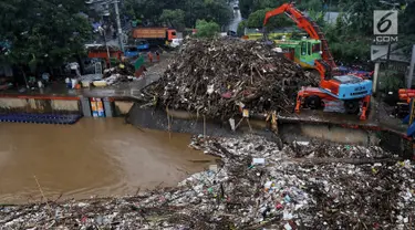 Alat berat (becko) beroperasi mengangkut sampah yang menumpuk di Pintu Air Manggarai, Jakarta, Rabu (24/4). Tingginya curah hujan di Bogor membuat sampah yang berasal kebanyakan dari sampah rumah tangga ini terbawa arus sungai menumpuk di Pintu Air Manggarai. (Liputan6.com/Johan Tallo)