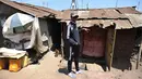 Henry Ohanga alias Octopizzo berpose di depan rumah milik kakeknya saat berkunjung ke Kibera di Nairobi, Kenya (16/1). Octopizzo akan menggunakan kesukseannya untuk membantu anak-anak di daerah kumuh tersebut. (AFP Photo/Tony Karumba)