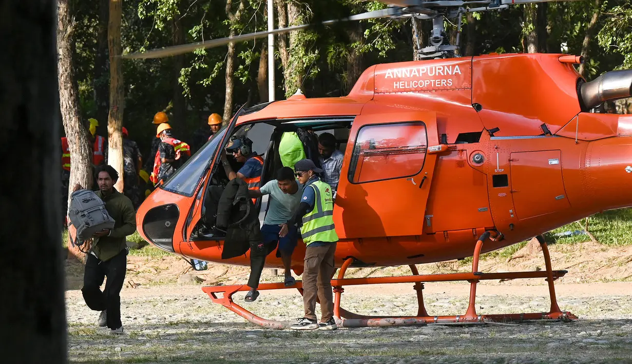 Warga yang berhasil diselamatkan turun dari helikopter di sebuah kamp militer setelah bencana banjir bandang di kota Battar Bazar, Distrik Nuwakot, Nepal, Kamis, pada 27 Agustus 2026. (AFP/ Prakash Mathema)