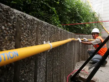 Pekerja memasang instalasi Gaslink PGN di Gedung Kementerian BUMN, Jakarta, Senin (9/10). Gaslink merupakan inovasi PGN memperluas pemanfaatan gas bumi ke masyarakat, salah satunya melalui pendistribusian gas tanpa melalui pipa (Liputan6.com/Angga Yuniar)