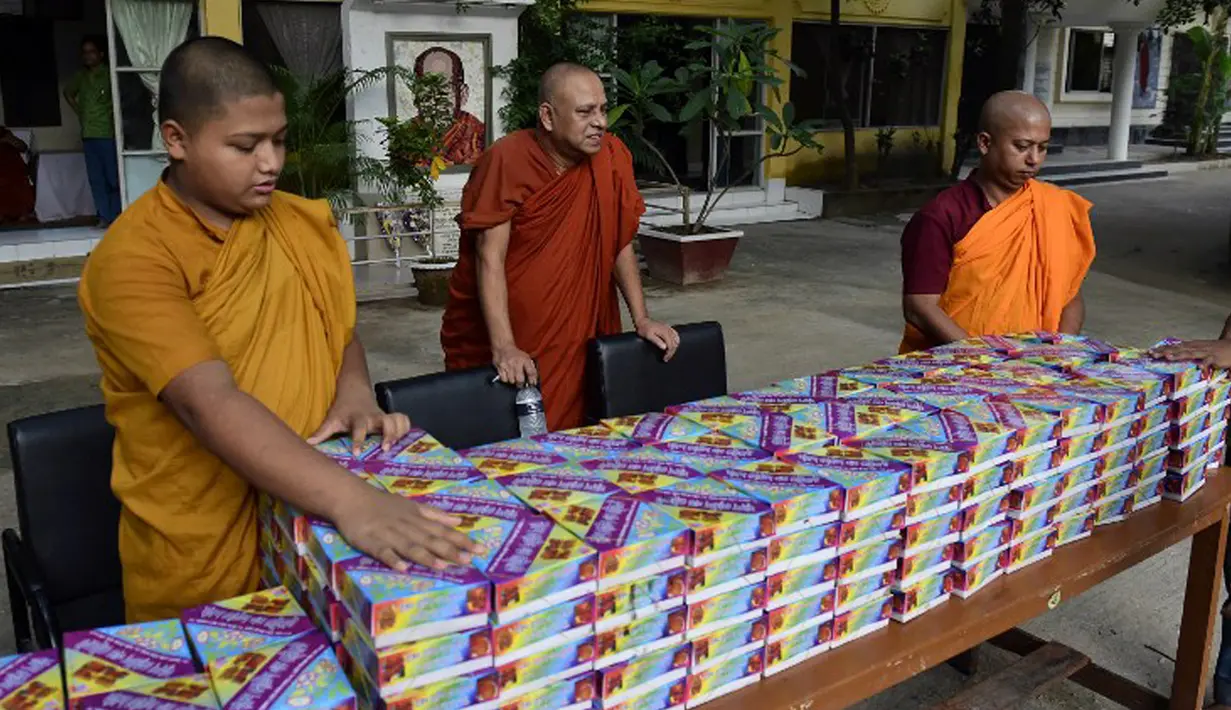 Sejumlah biksu menyiapkan iftar (makanan berbuka puasa) bagi umat muslim di Wihara Dhammarajika, Dhaka, Bangladesh, Selasa (7/7). Ini merupakan momen langka keharmonisan umat beragama di negara Asia. (AFP PHOTO/Munir uz ZAMAN)