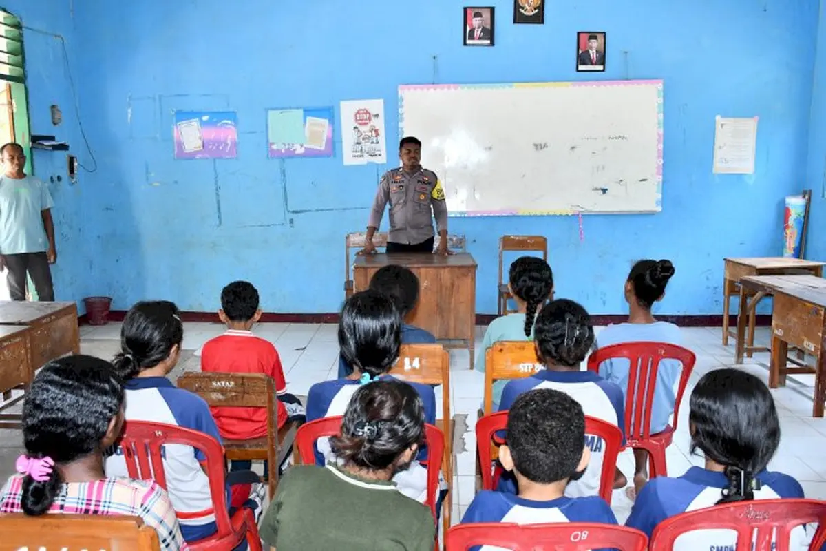 Bhabinkamtibmas Polres Flores Timur, Briptu Kelen, saat menjadi guru bagi siswa yang terdampak perang tanding (Liputan6.com/Ola Keda)