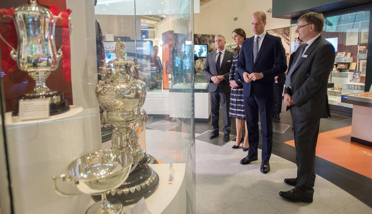 Pengeran Wiliam ditemani Kate Middleton melihat piala yang dipajang di Museum Nasional Sepak Bola di Manchester, Inggris (14/10). Kunjungan ini untuk memberi penghormatan kepada olahraga favorit Inggis, yaitu sepak bola. (Reuters/Charlotte Graham)