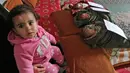Bocah perempuan duduk dekat adik kembarnya yang diberinama Jerusalem, Capital dan Palestine di Khan Yunis, Jalur Gaza, Jumat (2/2). Pasangan Nidal dan Islam Al-Saiqli memberi nama unik kepada tiga bayi kembar mereka yang baru lahir. (SAID KHATIB/AFP)