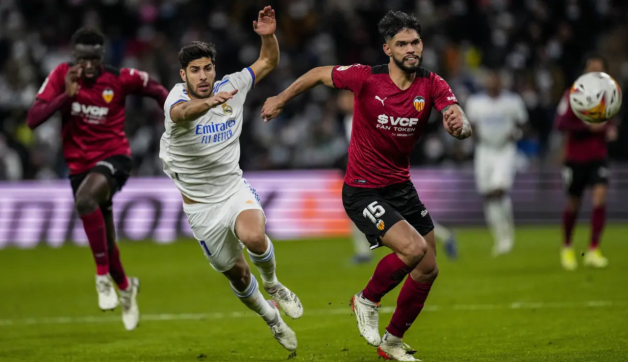 Penyerang Real Madrid Marco Asensio berebut bola dengan bek Valencia Omar Alderete (kanan) pada laga pekan ke-20 La Liga Spanyol di Santiago Bernabeu Valencia, Minggu dini hari WIB (9/1/2022). Real Madrid menang meyakinkan 4-1 atas Valencia. (AP Photo/Bernat Armangue)