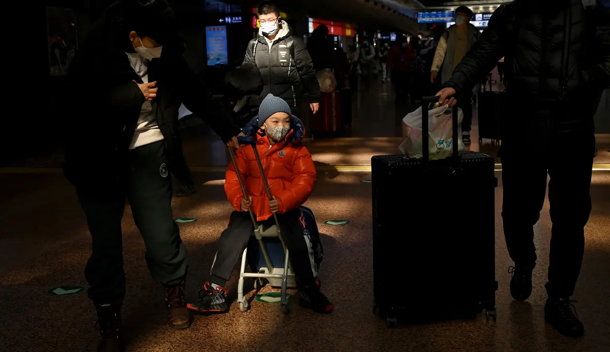 Penumpang tiba di stasiun kereta api Beijing Barat menjelang liburan Tahun Baru Imlek di Beijing, Kamis (27/1/2022). Tahun Baru Imlek 2022 yang jatuh pada 1 Februari mendatang akan jadi tahun shio macan. (AFP/Noel Celis)