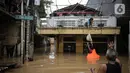 Warga menurunkan barang saat banjir di kawasan Rawajati, Kalibata, Jakarta, Senin (10/10/2022). Tingginya curah hujan di kawasan Bogor mengakibatkan ratusan rumah di enam RT Kelurahan Rawajati terendam banjir dengan ketinggian mencapai dua meter. (Liputan6.com/Faizal Fanani)