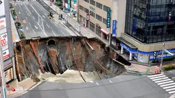Penampakan lubang raksasa atau biasa disebut sinkhole yang tiba-tiba muncul di persimpangan dekat Stasiun Hakata, Fukuoka, Jepang, Selasa (8/11). Insiden itu mengakibatkan lalu lintas terputus, pemadaman listrik serta kebocoran gas. (Kyodo/via REUTERS)