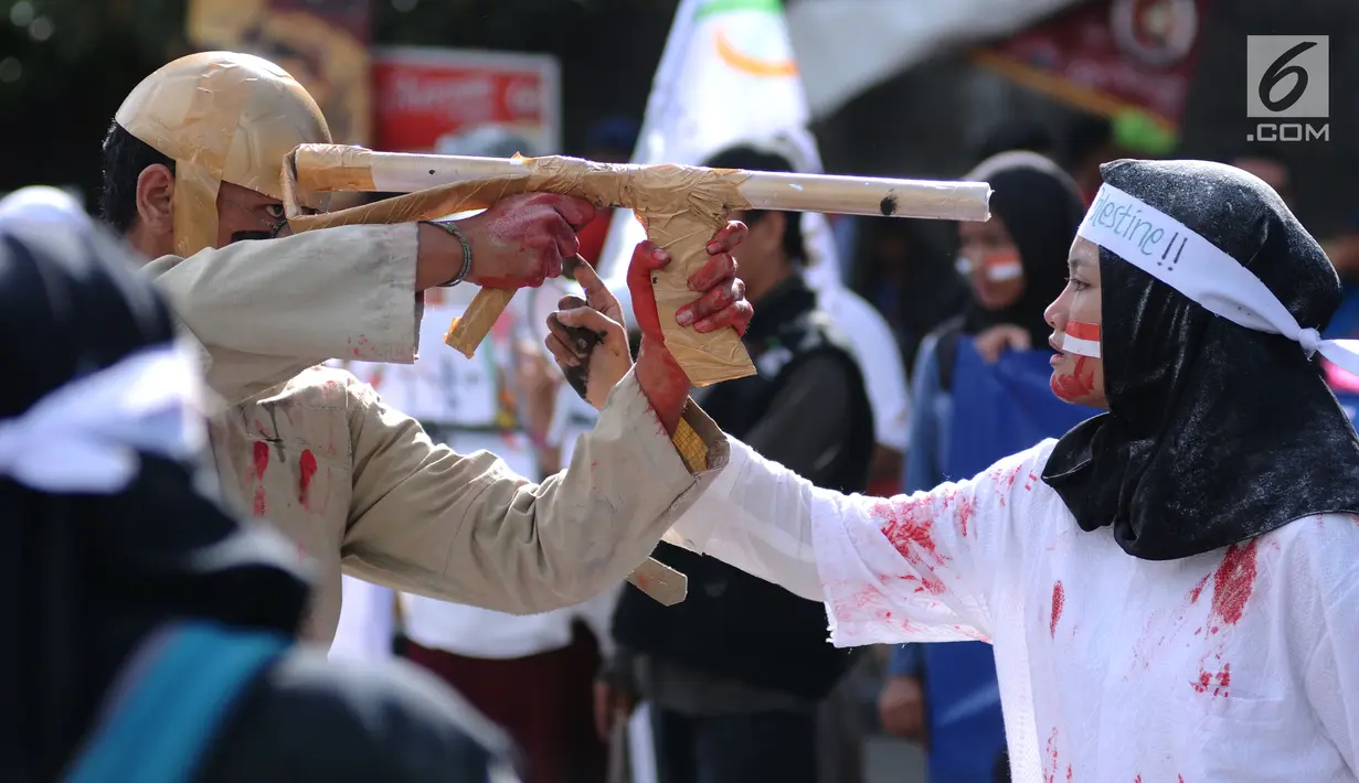 Peserta aksi melakukan teatrikal tentang kekejaman tentara Israel di kawasan Bundaran HI, Jakarta, Minggu (10/12). Selain itu, mereka juga melakukan aksi penggalangan tanda tangan dan dukungan bagi negara Palestina. (Liputan6.com/Helmi Fithriansyah)