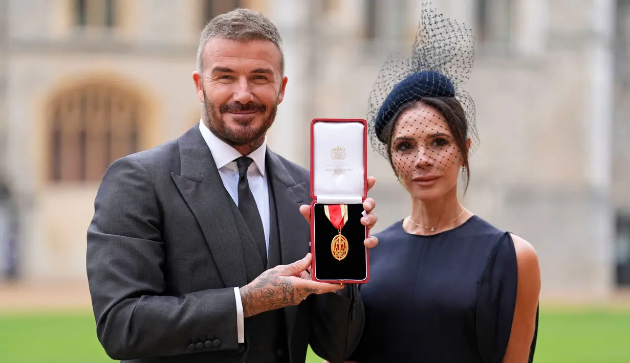 Mantan pesepak bola, Sir David Beckham (kiri) berfoto bersama dengan istrinya, Victoria Beckham sambil menunjukkan medali setelah dinobatkan gelar baru oleh raja Inggris, Charles III di Kastil Windsor, Berkshire, Inggris, Selasa (04/11/2025) waktu setempat. (AP Photo/Pool/Andrew Matthews)