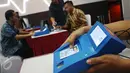 Petugas menunjukan cara kerja alat pembaca kartu atau card reader e-KTP di Jakarta, Kamis (6/4). Dengan alat ini hanya dibutuhkan waktu 30 menit untuk proses pembukaan rekening investor. (Liputan6.com/Angga Yuniar)