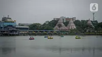 Pengunjung menaiki perahu angsa di kawasan Taman Mini Indonesia Indah, Jakarta, Minggu (12/10/2021). Uji coba pengoperasian tempat wisat ini harus  dengan Kapasitas pengunjung pada masa uji coba dibatasi hanya 25 persen. (Liputan6.com/Faizal Fanani)