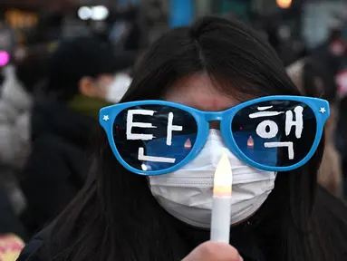 Seorang pengunjuk rasa mengenakan kacamata bertuliskan “Pemakzulan” dalam sebuah demonstrasi yang menuntut pengunduran diri Presiden Yoon Suk Yeol di luar Majelis Nasional, Seoul, Korea Selatan pada tanggal 10 Desember 2024. (Jung Yeon-je/AFP)