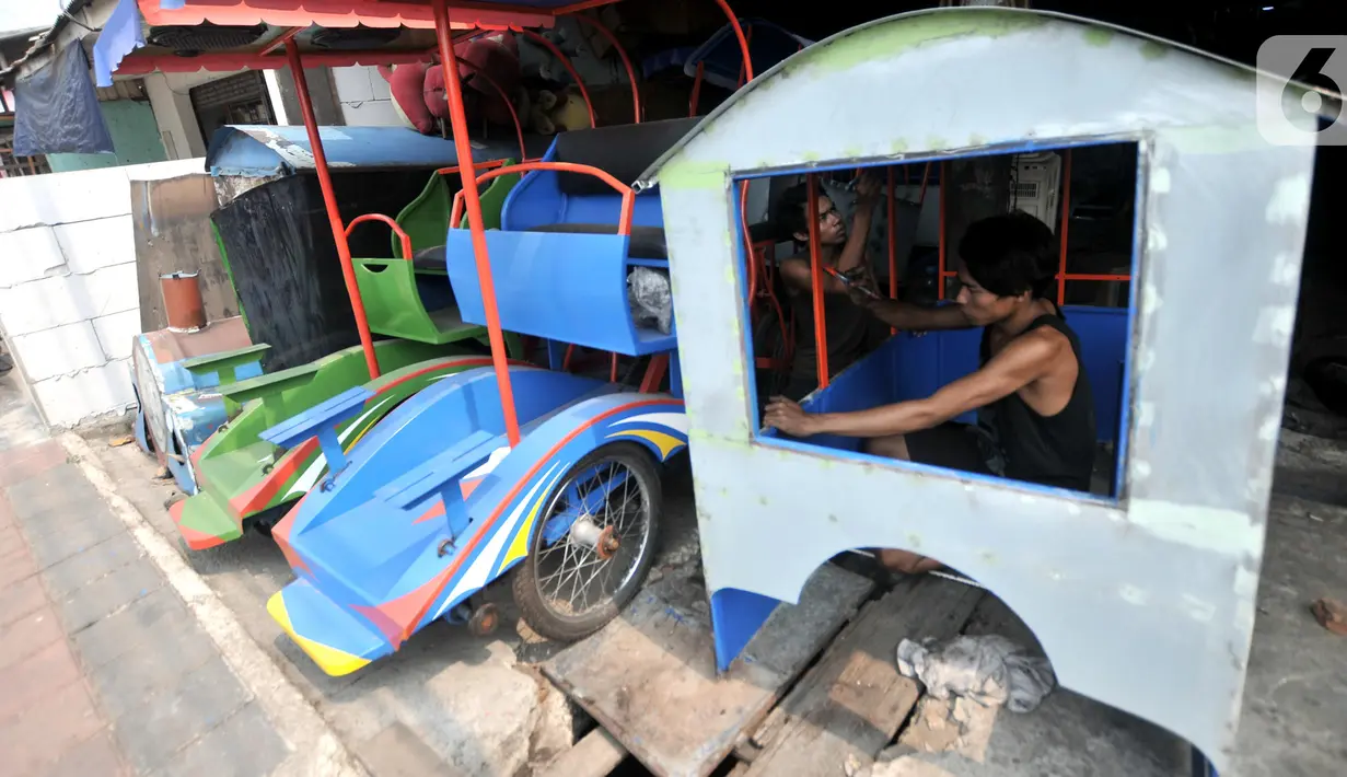 Pekerja menyelesaikan odong-odong, Jakarta, Rabu (30/10/2019). Kini, Asep harus mencari cara bertahan hidup dengan odong-odong di tengah larangan Dishub DKI terhadap kendaraan hiburan warga menengah ke bawah itu karena berdampak pada permintaan pelanggan. (merdeka.com/Iqbal S. Nugroho)