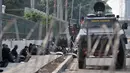 Pollisi beristirahat disamping kendaraan taktis yang menutup akses menuju Gedung DPR RI di Jalan Gatot Subroto, Jakarta, Kamis (26/9/2019). Polisi menutup jalan mulai dari simpang Gerbang Pemuda guna mengantisipasi adanya aksi unjuk rasa susulan. (merdeka.com/Iqbal S Nugoroho)