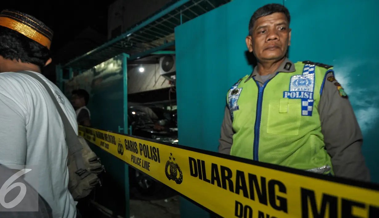 Petugas membentangkan garis polisi gudang yang diduga digunakan untuk membuat sabu, Jakarta (25/7). Kepolisian Polda Metro Jaya menggerebek sebuah gudang yang diduga pabrik narkoba jenis sabu di kawasan Penjaringan. (Liputan6.com/Yoppy Renato)