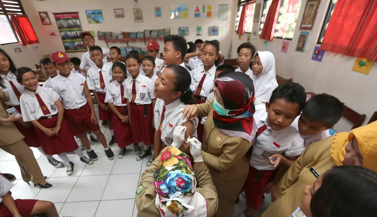 Siswa SD menunggu giliran untuk disuntik difteri di sebuah sekolah dasar di Tangerang,  Senin (11/12). Indonesia memulai sebuah kampanye untuk mengimunisasi 8 juta anak-anak dan remaja dari difteri. (AP Photo / Tatan Syuflana)