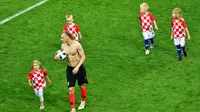 Bek Kroasia, Domagoj Vida bersama anak-anak pemain Kroasia berjalan di lapangan usai menundukkan Inggris di laga semifinal Piala Dunia 2018 di Stadion Luzhniki, Moskow, Rusia, Rabu (11/7). (MLADEN ANTONOV/AFP)
