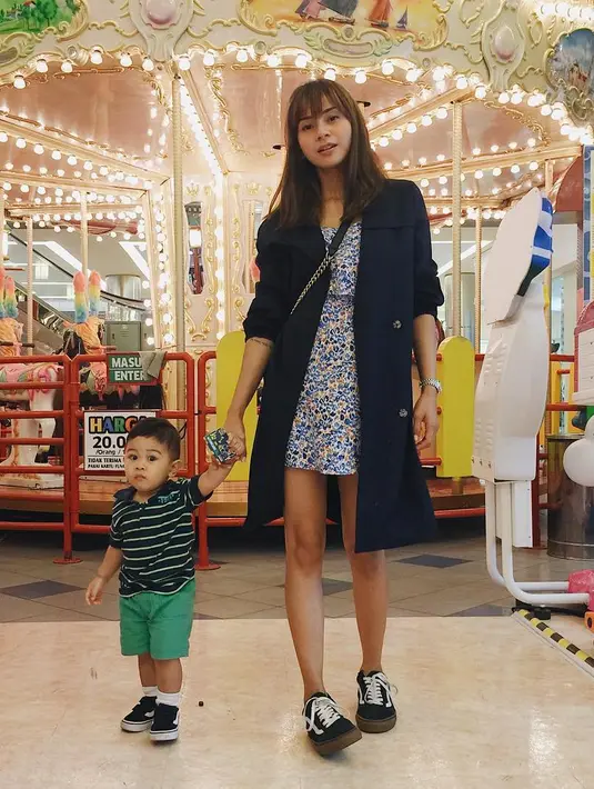 Untuk yang satu ini Kirana terlihat sedang bermain dengan buah hatinya, dan penampilannya  pun tampak seksi. Ia memakai mini dress berwarna biru yang dipadukan dengan outer berwarna biru. (Instagram/kiranalarasati)