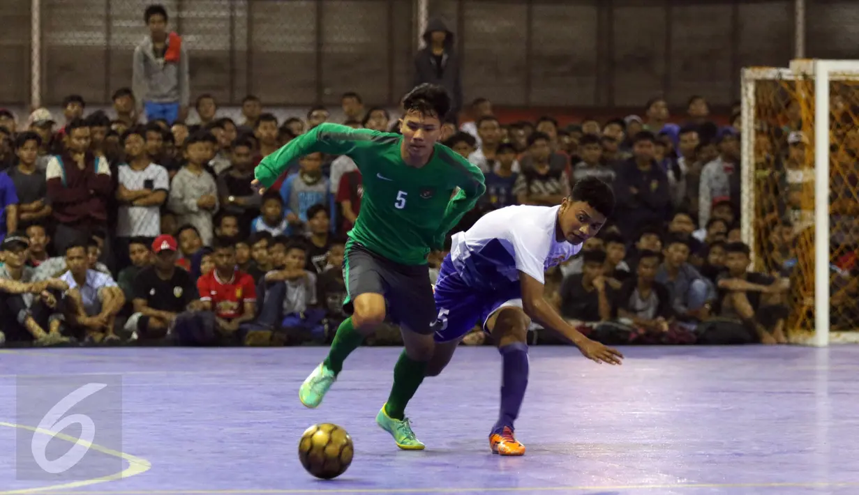Pemain Timnas Futsal Indonesia, Septyan DC (kiri) berebut bola dengan pemain IPC Pelindo II saat laga uji coba di Jakarta, Minggu (15/1). Timnas Futsal Indonesia akan melakoni laga piala AFF 2017, akhir Januari. (Liputan6.com/Helmi Fithriansyah)