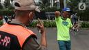 Satpol PP menegur warga yang berolahraga tidak mengenakan masker dengan benar di kawasan Bundaran HI, Jakarta, Minggu (17/1/2021). Sosialisasi penggunaan masker untuk mencegah penularan virus corona COVID-19 masih saja diabaikan karena rendahnya kesadaran masyarakat. (Liputan6.com/Johan Tallo)