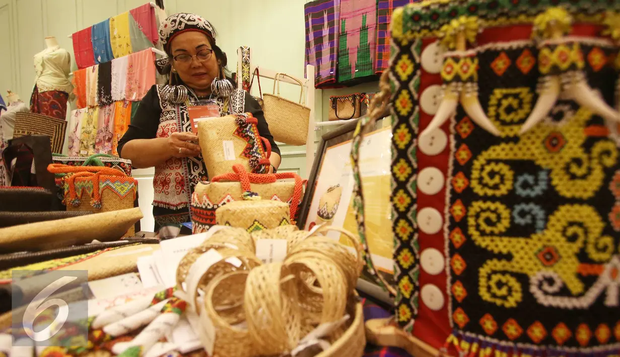 Peserta merapikan produk saat pemeran bertajuk Karya Kreatif Indonesia di Jakarta, Jumat (26/8). Pameran tersebut diselenggarakan dalam rangka mempromosikan produk Usaha Mikro Kecil Menengah (UMKM) dari seluruh Indonesia. (Liputan6.com/Immanuel Antonius)