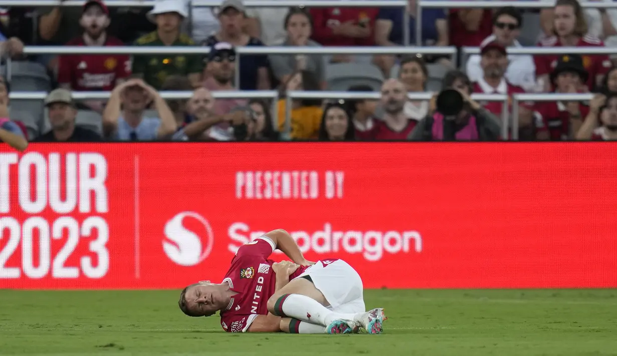 Pemain Wrexham, Paul Mullin terkapar sambil mengeram kesakitan setelah mengalami berbenturan dengan kiper Manchester United, Nathan Bishop pada laga uji coba pramusim di Snapdragon Stadium, San Diego, California, Rabu (25/07/2023) WIB. (AP Photo/Gregory Bull)