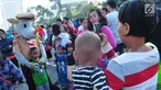 Seorang anak berfoto dengan boneka Pramuka dalam aksi Satu Indonesia di area Car Free Day (CFD), Bundaran HI, Minggu (30/7). Aksi tersebut bertajuk “Satu Nusa, Satu Bangsa, Satu Bahasa, Indonesia”. (Liputan6.com/Helmi Afandi)