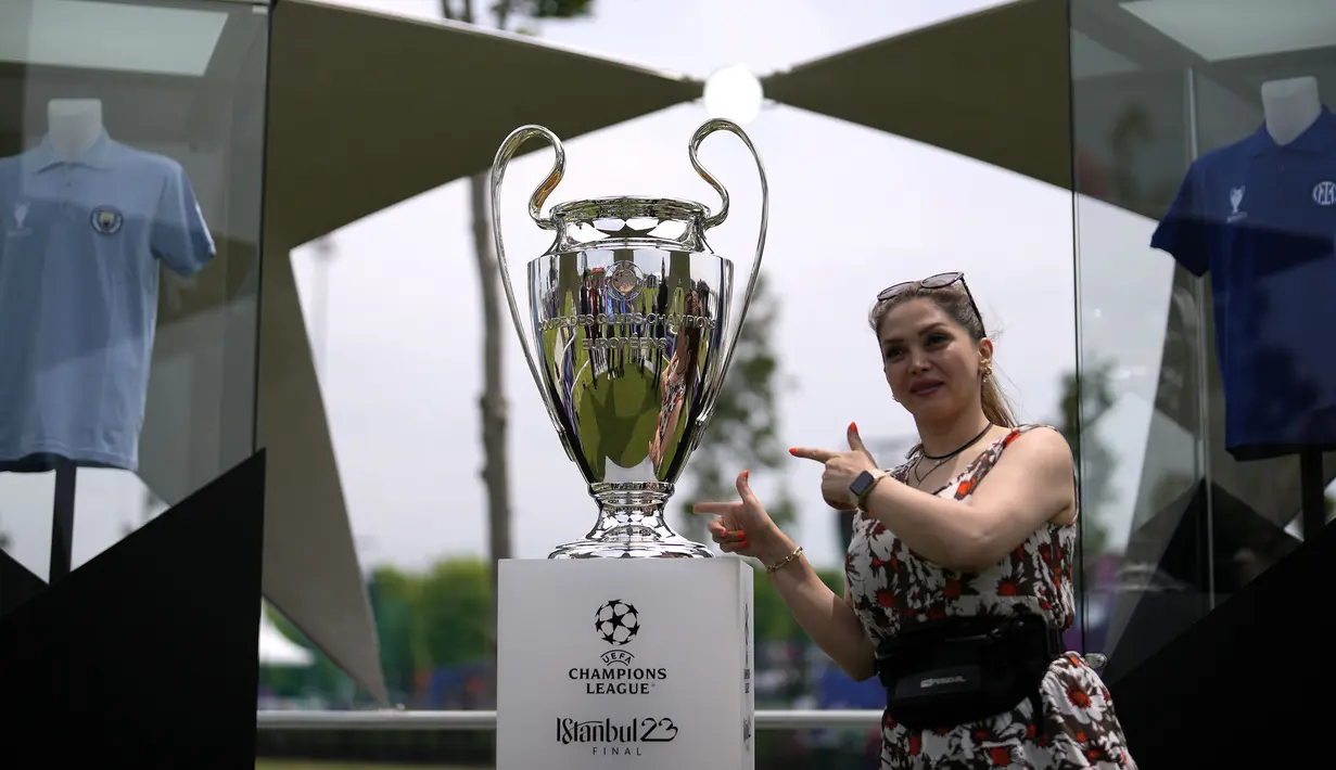 Seorang pengunjung perempuan berfoto dengan trofi Liga Champions di Istanbul, Turki, Kamis (8/6/2023). Laga final yang mempertemukan Inter Milan melawan Manchester City akan berlangsung di Atatürk Olympic Stadium, Istanbul, Turki, Minggu (9/6/2023) dini hari WIB. (AP Photo/Khalil Hamra)