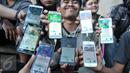 Komunitas Pokemon Go (Instinct Depok Team) menunjukan pokemon hasil berburu mereka di area Kampus Universitas Indonesia (UI) Depok, Sabtu (6/8). Game augmented reality Pokemon Go akhirnya resmi hadir di Indonesia. (Liputan6.com/Yoppy Renato)