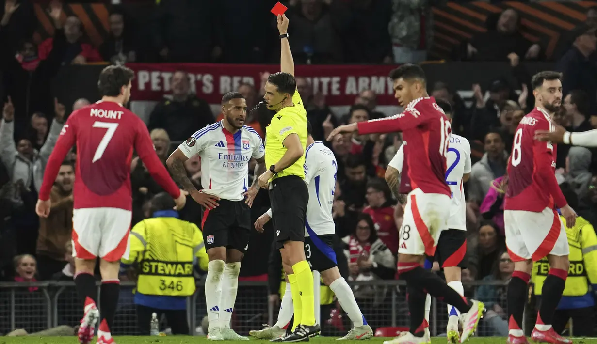 Pemain Lyon, Corentin Tolisso mendapatkan kartu merah dari wasit dalam laga lanjutan Liga Europa 2024/2025 melawan Manchester United di Old Trafford, Manchester, Inggris, Jumat (18/04/2025) dini hari WIB. (AP Photo/Jon Super)