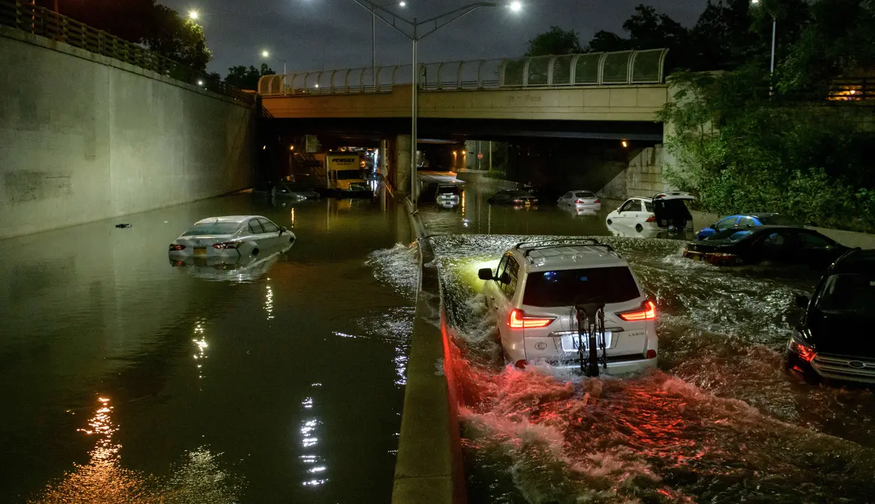 Sejumlah mobil terjebak banjir yang merendam jalanan di Brooklyn, New York, Amerika Serikat, Kamis (2/9/2021). Banjir bandang terjadi di sejumlah titik di pusat kota New York setelah hujan lebat yang dipicu Badai Ida mengguyur kota tersebut. (AFP/Ed Jones)